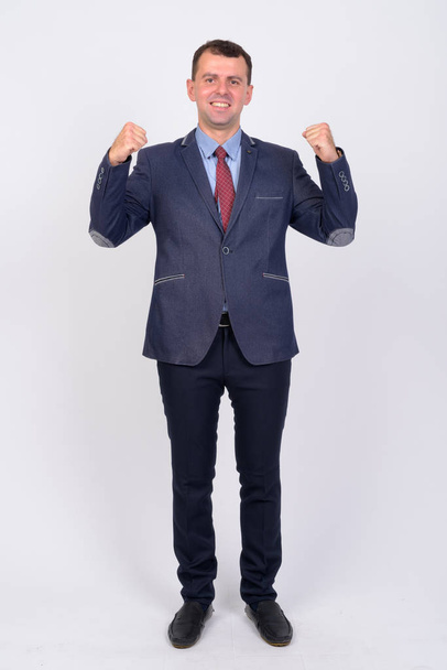 Full body shot of happy businessman in suit with getting good news - Photo, image