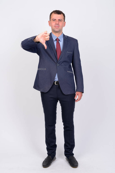 Full body shot of businessman in suit giving thumbs down - Foto, immagini