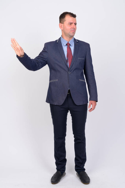 Full body shot of businessman in suit showing stop gesture - Фото, зображення