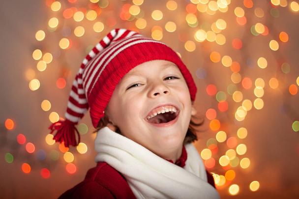 Chico risueño en sombrero de Navidad, fondo colorido
 - Foto, imagen