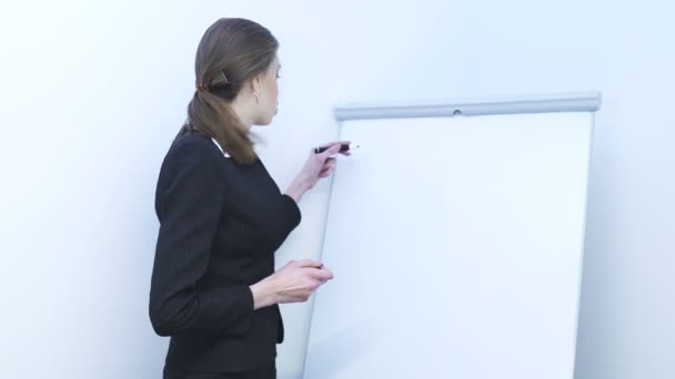       4K.Pretty young business woman  draws schedule on flip chart. Presentation - Footage, Video