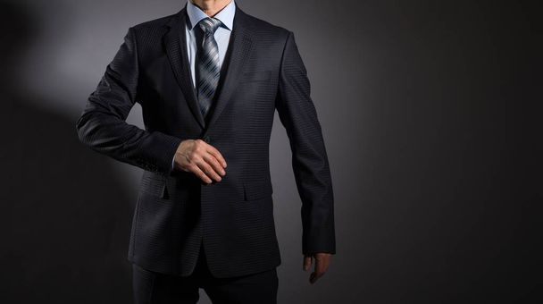 A man in an elegant suit on a dark background. Men's fashion. - Foto, Imagem