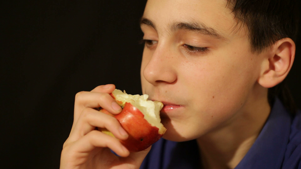Çocuk bir elma yiyor. - Video, Çekim
