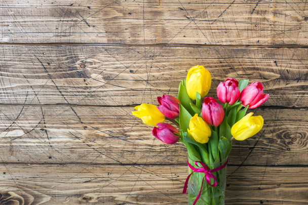 Bouquet of yellow and pink tulips on a wooden background - Fotografie, Obrázek