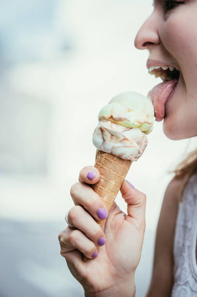 Young girl enjoys ice cream in the summer, blurry - Фото, изображение