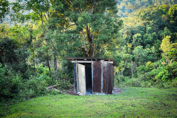 Ancienne forêt de toilettes en bois avec toit en zinc sur les montagnes dans une colline du village - Cabines de toilettes extérieures
 - Photo, image