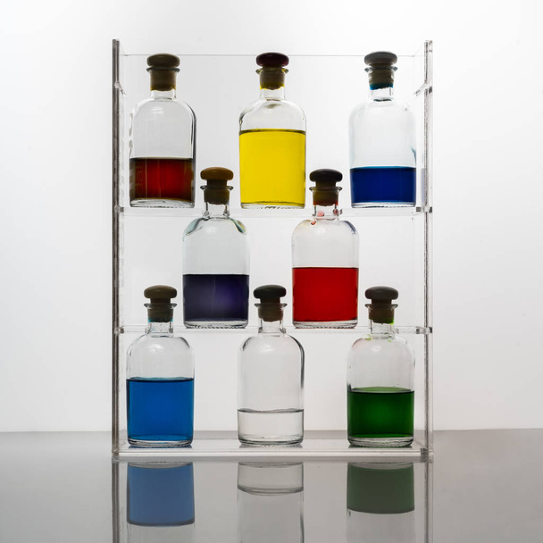 Small glass bottles containing colored liquid - Photo, image