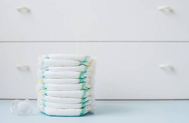 A stack of diapers against a white wardrobe - Photo, Image