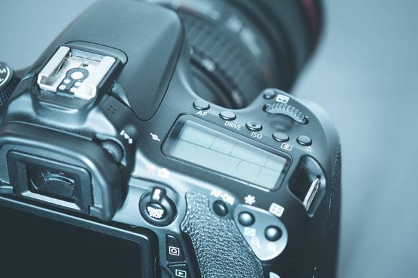 Professional reflex camera with telephoto lens on the table, cutout, blurry background - Zdjęcie, obraz