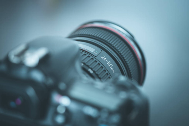 Professional reflex camera with telephoto lens on the table, cutout, blurry background - Φωτογραφία, εικόνα