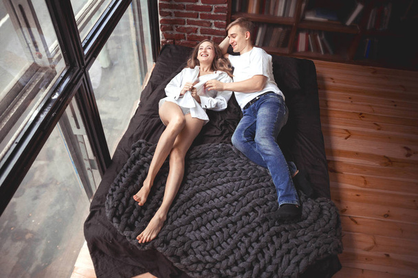 молодий чоловік і жінка лежать в ліжку і отримують задоволення
 - Фото, зображення