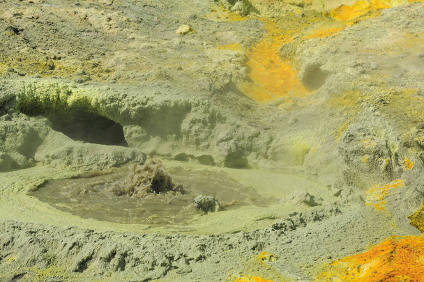Piscina de barro hirviendo rodeada de depósitos de azufre amarillo en el humeante paisaje volcánico caliente de White Island, Nueva Zelanda
  - Foto, imagen