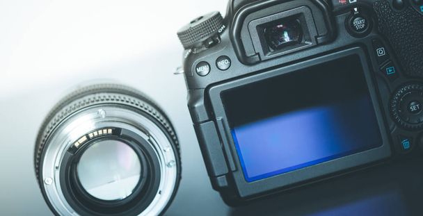 Back view of a professional reflex camera with flip lsd screen and a photo lens - Fotó, kép
