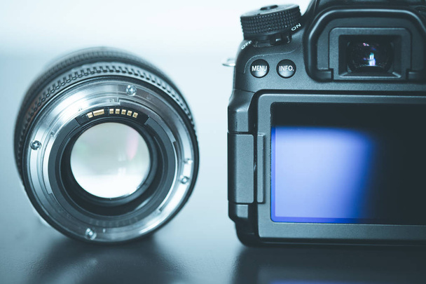 Back view of a professional reflex camera with flip lsd screen and a photo lens - Fotó, kép