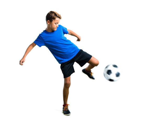 Снимок мальчика, играющего в футбол, пинающего мяч на изолированном белом фоне
 - Фото, изображение