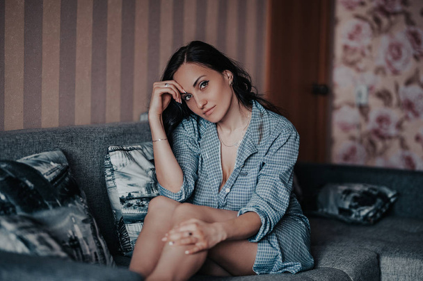 Beautiful brunette young girl posing in grey shirt for photo at home studio - Valokuva, kuva