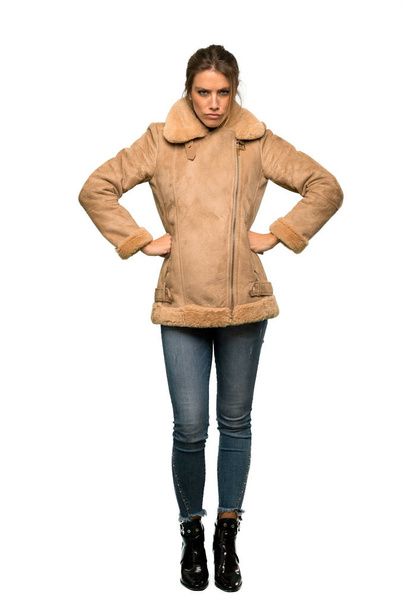 A full-length shot of a Blonde woman with a coat angry over isolated white background - Fotó, kép