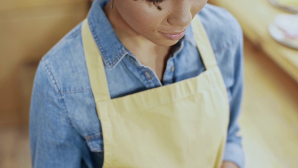 bonito sorrindo africano americano caixa feminina em avental usando smartphone com tela em branco no café
 - Filmagem, Vídeo