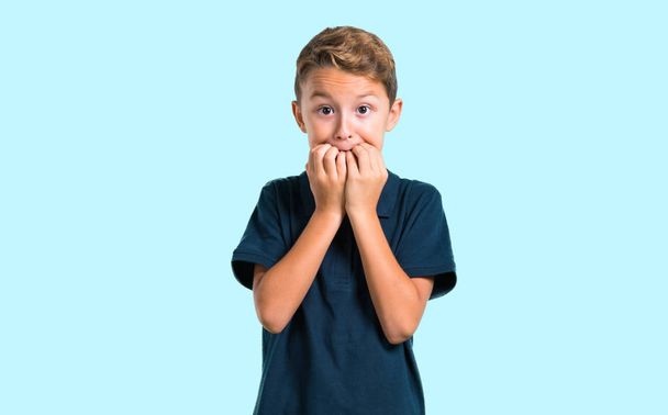 Little boy is a little bit nervous and scared on blue background - Photo, Image