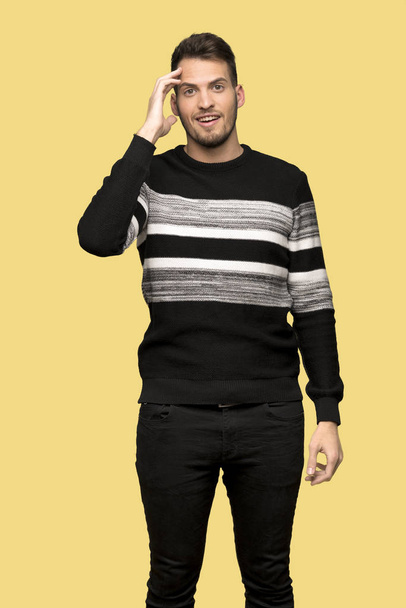 Handsome man has just realized something and has intending the solution over yellow background - Photo, Image