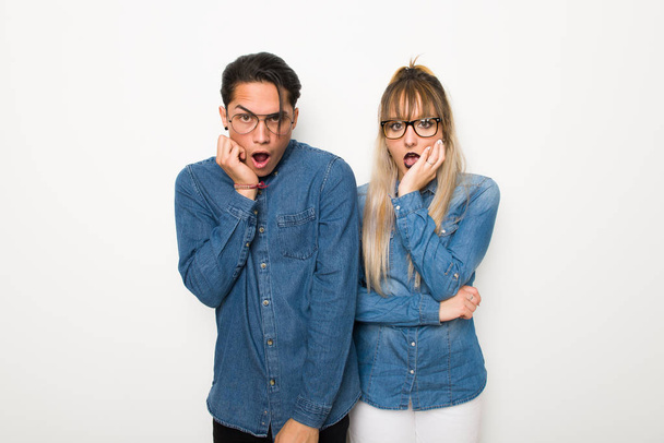 Jovem casal com óculos surpreso e chocado ao olhar para a direita
 - Foto, Imagem