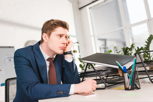 bored businessman sitting near document tray in office  - Photo, Image