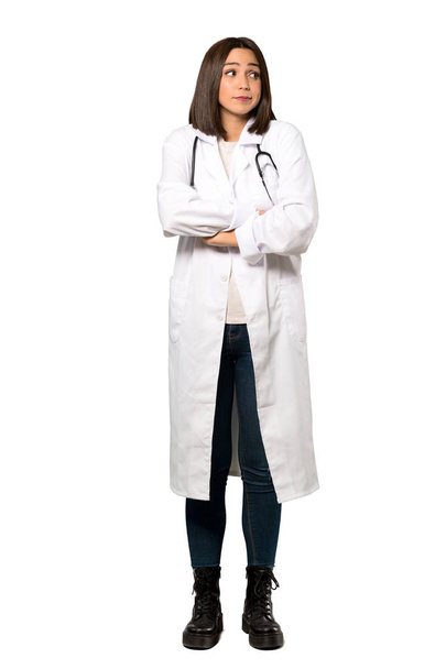 Una toma completa de una joven doctora haciendo un gesto de dudas mientras levanta los hombros sobre un fondo blanco aislado
 - Foto, imagen