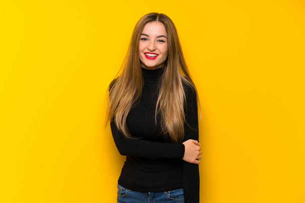 Young pretty woman over yellow background With happy expression - Фото, зображення