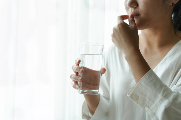 baş ağrısı kadın bir bardak su, sağlık ve tıp kurtarma kavramı ile ilacı - Fotoğraf, Görsel