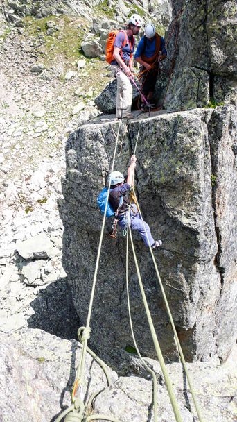 rock climbers traverse and climb the Clocher de Planpraz climbing route in the French Alps above Chamonix - Photo, Image
