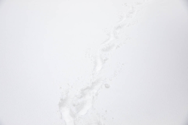 κοντινή λήψη ενός πατημασιές στο λευκό χιόνι - Φωτογραφία, εικόνα