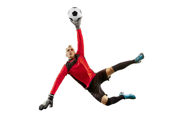 Male soccer player goalkeeper catching ball in jump. Silhouette of fit man with ball isolated on white studio background - 写真・画像