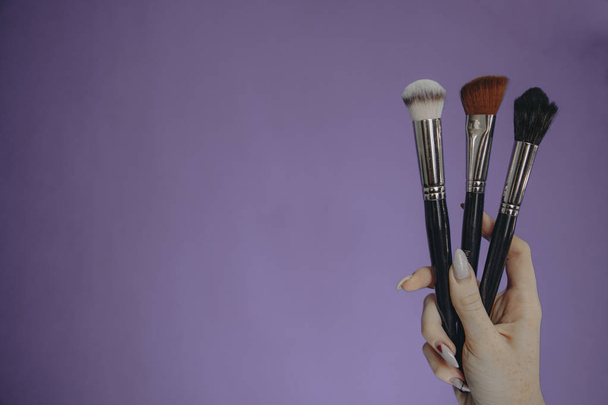Make-up borstels op paarse achtergrond - Foto, afbeelding