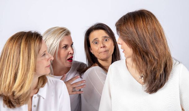 Grupo de 4 mulheres, amigos, meia-idade se divertindo em uma sessão de fotos em um estúdio com fundo branco
 - Foto, Imagem
