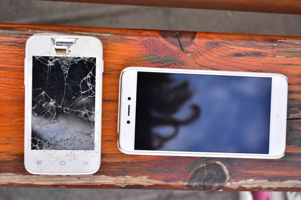  uszkodzony telefon na drewnianym tle - Zdjęcie, obraz