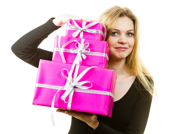 Happy positivie young teenage woman holding big pile of pink gift boxes. Female receiving many presents. - Fotoğraf, Görsel