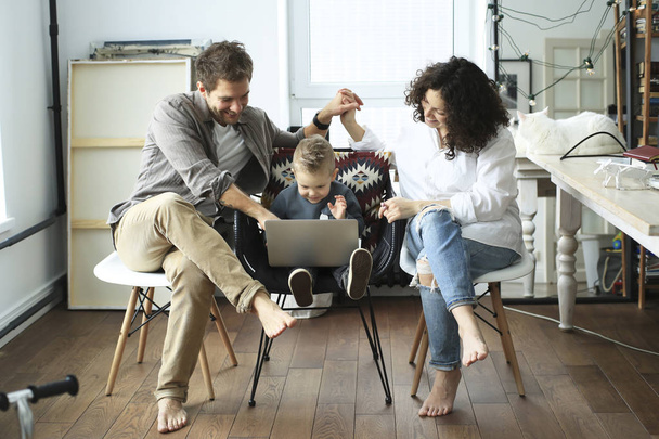 Young family with laptop in bright room at home - Foto, Imagem