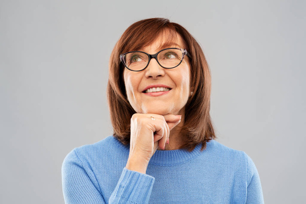 portrait of senior woman in glasses dreaming - Foto, imagen