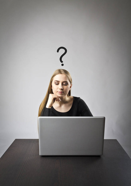 Nuori nainen käyttää kannettavaa tietokonetta selatakseen verkkoa. Kysymys, tietämättömyys ja ongelma käsite
. - Valokuva, kuva