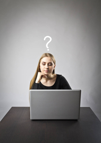 Nuori nainen käyttää kannettavaa tietokonetta selatakseen verkkoa. Kysymys, tietämättömyys ja ongelma käsite
. - Valokuva, kuva