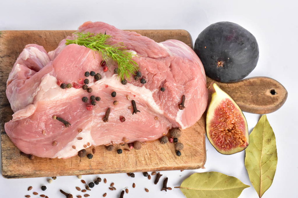 raw meat with spices and figs on wooden board  - Photo, Image