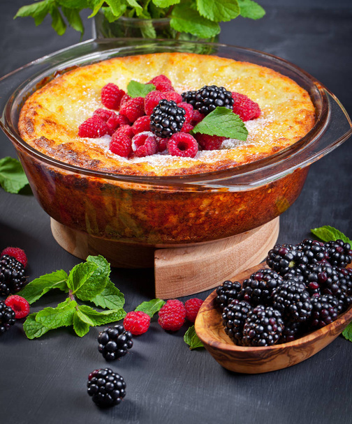 Curd cheese cake with raspberries, blackberries and mint leaves. Sugarless. Healthy diet. Black background - Photo, Image