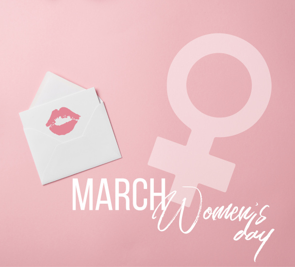 top view of greeting card with lips mark in white envelope with womens day and female sign illustration - Fotó, kép