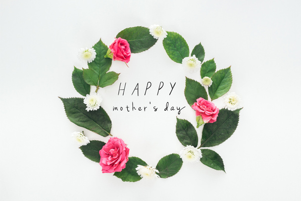 top view of circular composition with green leaves, roses and chrysanthemums on white background with happy mothers day illustration - Photo, Image