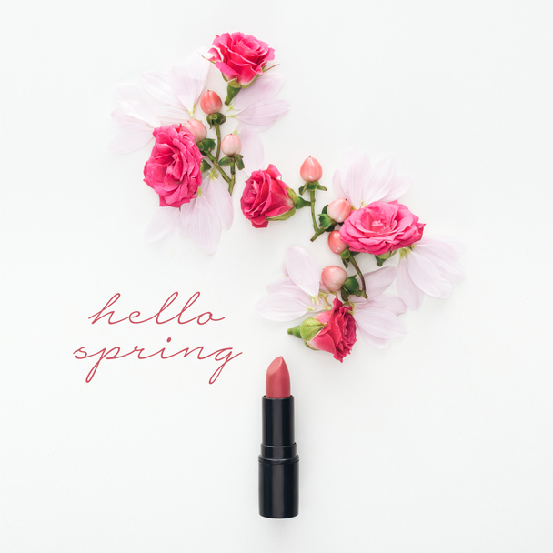 top view of composition with roses, buds and petals with lipstick on white background with hello spring lettering  - Photo, Image