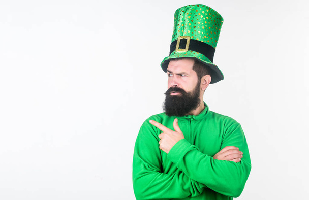 Drawing your attention. Hipster wearing leprechaun hat and costume pointing finger. Bearded man celebrating saint patricks day. Irish man with beard in green. Happy saint patricks day, copy space - Foto, immagini