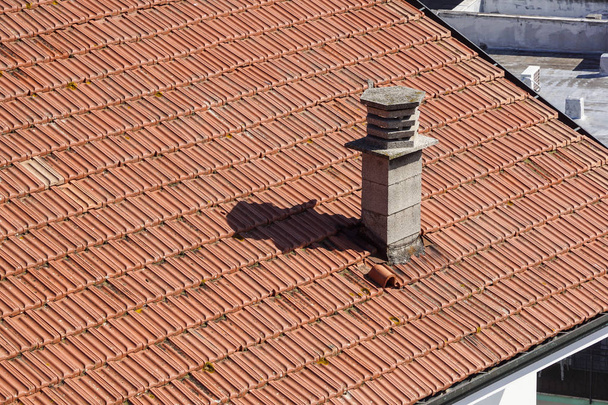 Μια κοντινή όψη μιας καμινάδας στην κορυφή κόκκινα πλακάκια στην οροφή - Φωτογραφία, εικόνα