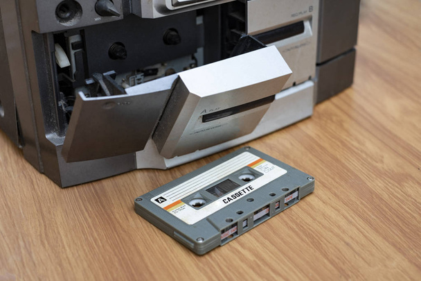 Урожай компактна касета та програвач звукової стрічки на фоні дерева столу
 - Фото, зображення