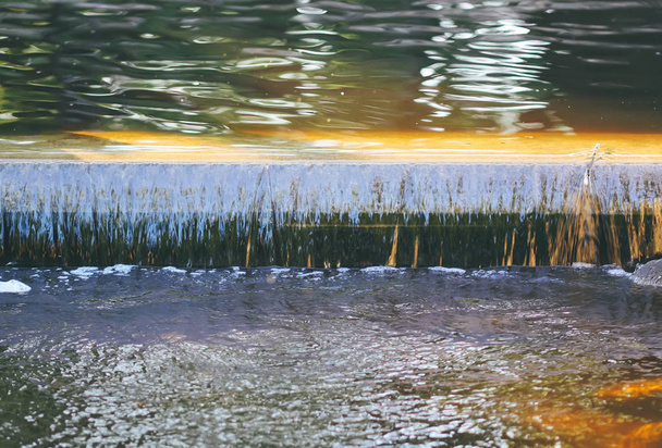 Koristeellinen keinotekoinen vesiputous kesäpuistossa
. - Valokuva, kuva