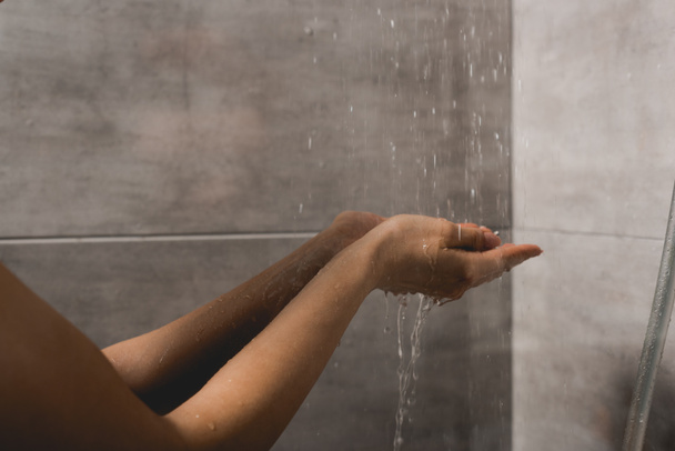 vista recortada de la mujer tomando ducha en cabina
  - Foto, Imagen